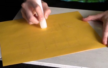 person writing on gold paper with a candle stick